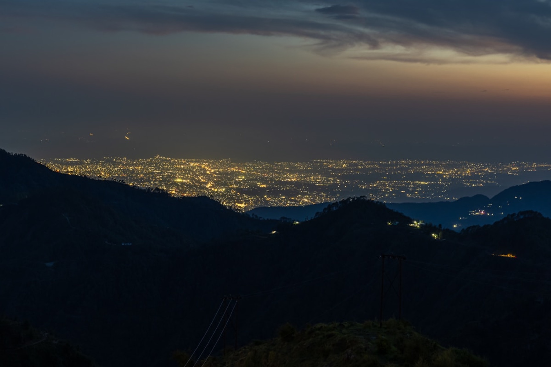 Las luces de Tegucigalpa vistas al anochecer desde la cresta boscosa de El Molino