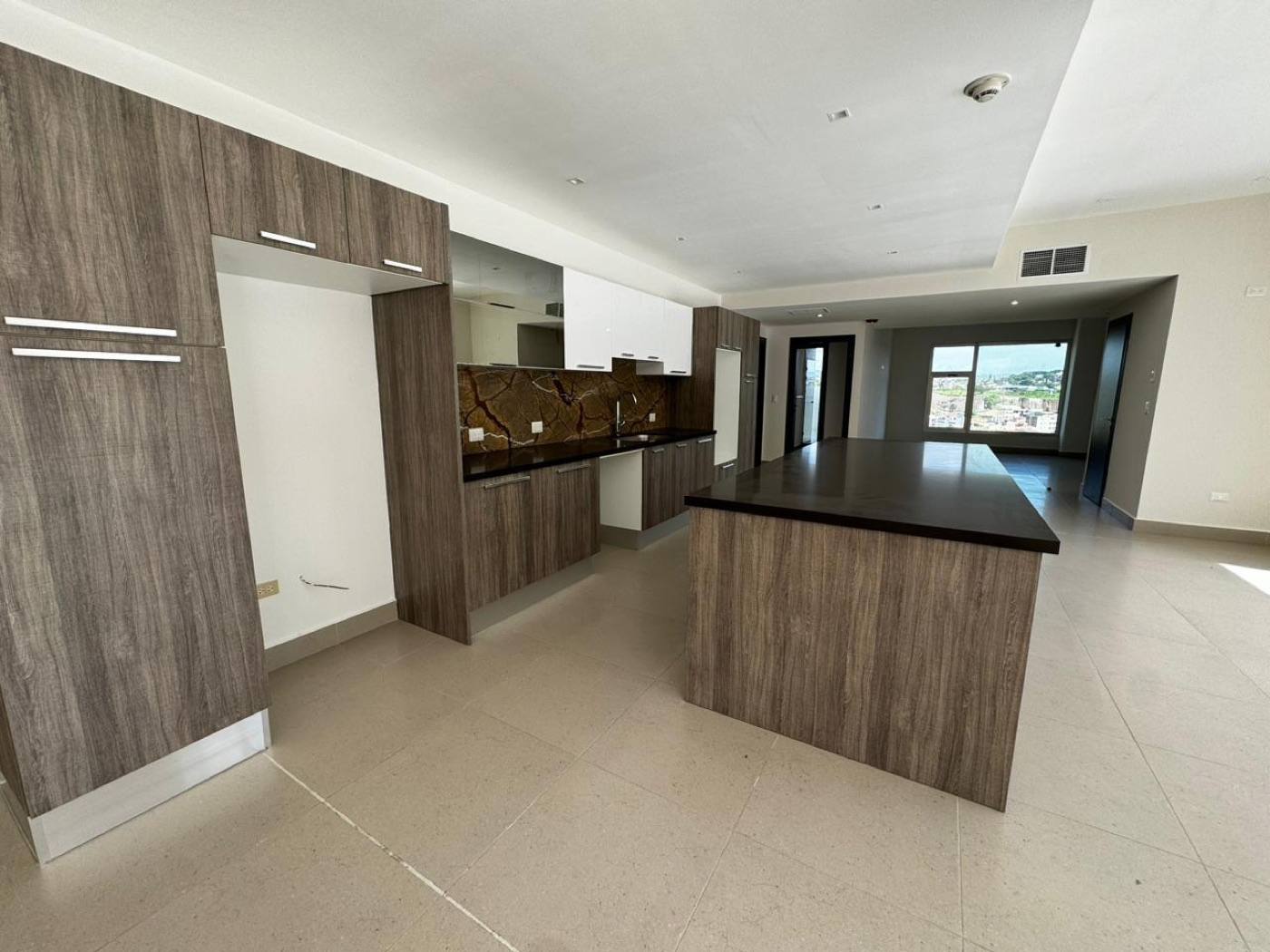 Cocina real de un apartamento del conjunto, con muebles de madera y vista abierta