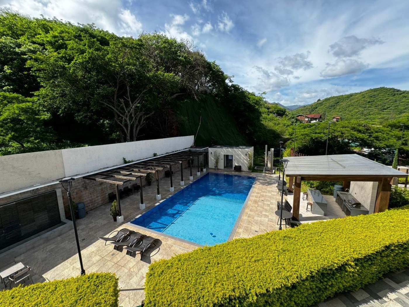 La piscina de Torres Taragón rodeada por la ladera verde de El Molino
