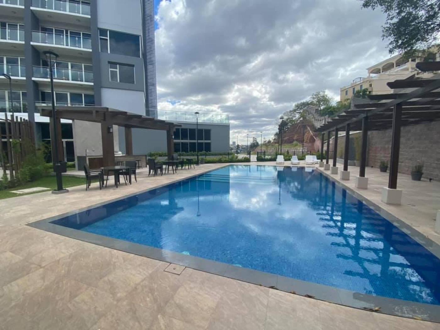 La piscina de Torres Taragón con su pérgola y terraza de tumbonas